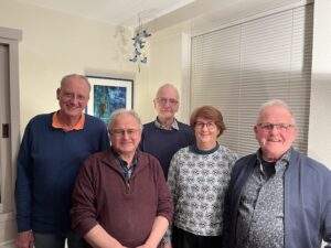 Vijf leden van het buurtinitiatief Oudkarspel poseren voor een foto en lachen naar een de camera.