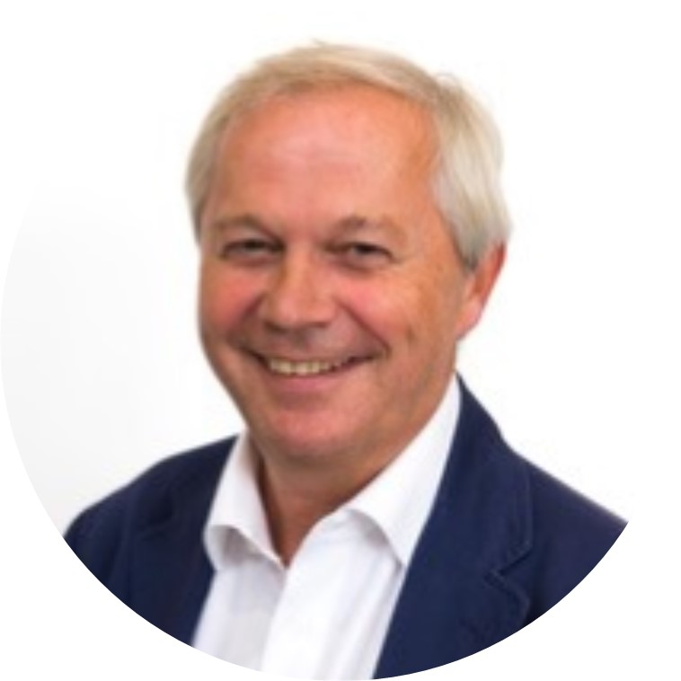 Een portret foto van Toon, lid van de Raad van Toezicht van Buurkracht, in een donkerblauw pak met wit overhemd voor een witte achtergrond.