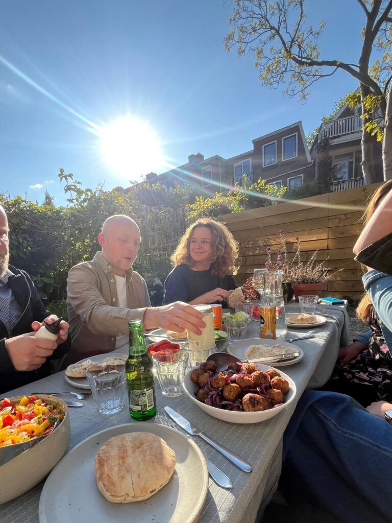 Een groep mensen eet samen in de Zegenstraat in Rotterdam-Zuid.